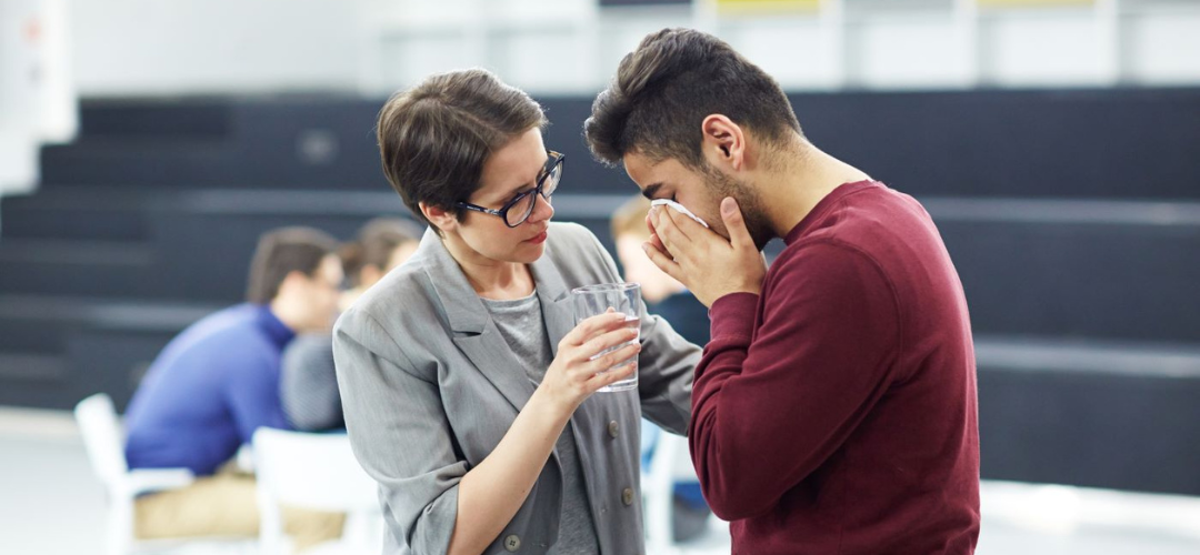 Woman helping a younger man who is upset.